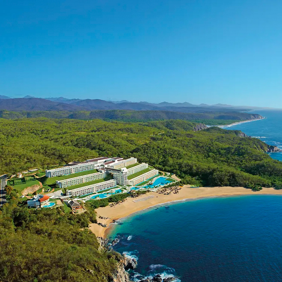 this is an aerial image of a secrets all-inclusive resorts Mexico Resort nested in the mountain with an private beach by Inclusive Collection