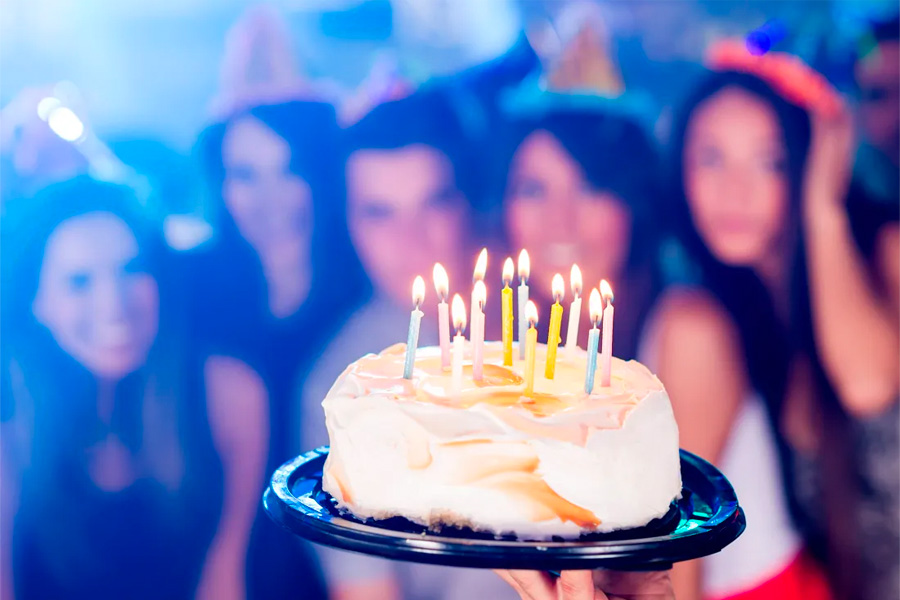 This is an image of people celebrating a birthday with a cake