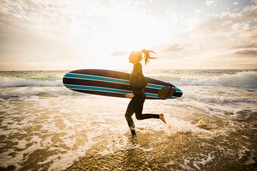 Woman with Surf board running in the beach