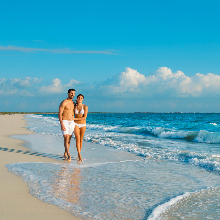 Esta es la imagen de una pareja caminando en la orilla del mar