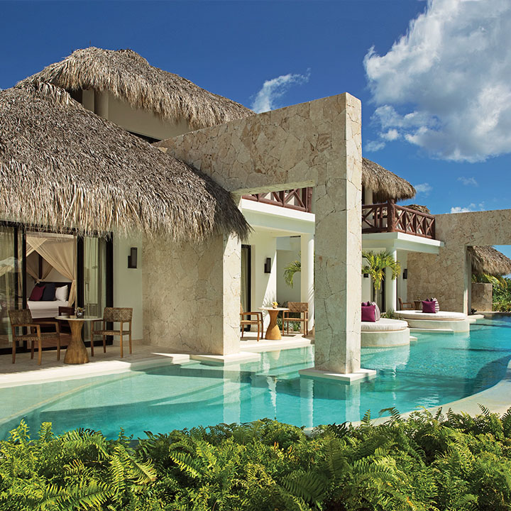 Esta es una imagen del exterior de una suite estilo bungalow con una gran piscina en Secrets Cap Cana Resort & Spa