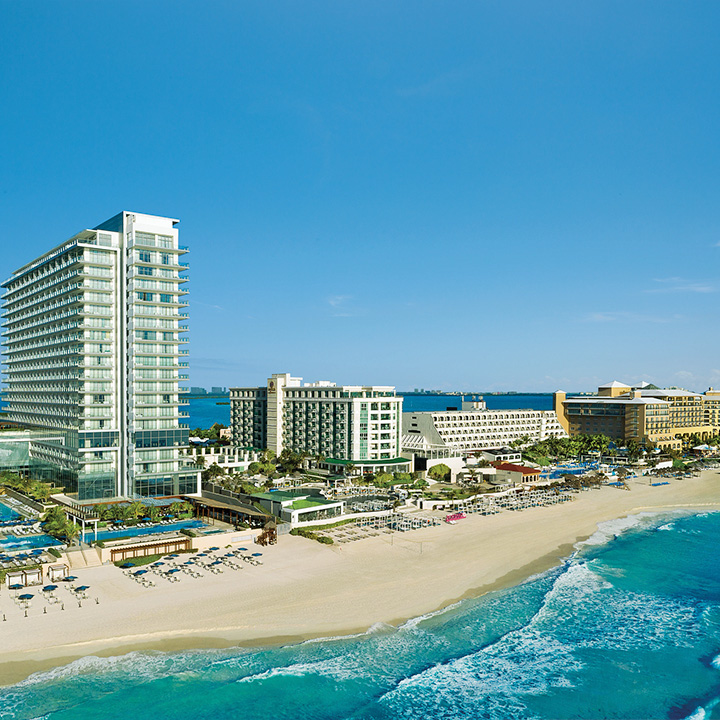 Esta es una imagen de la vista aérea lejana frente al mar de Secrets The Vine Cancún.